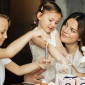 woman with her daughter and son at a table baking