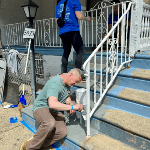 two people painting a porch